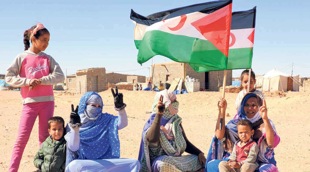 Tres saharauís fan o símbolo da vitoria nun campo de refuxiadas e refuxiados (Foto: cedida).