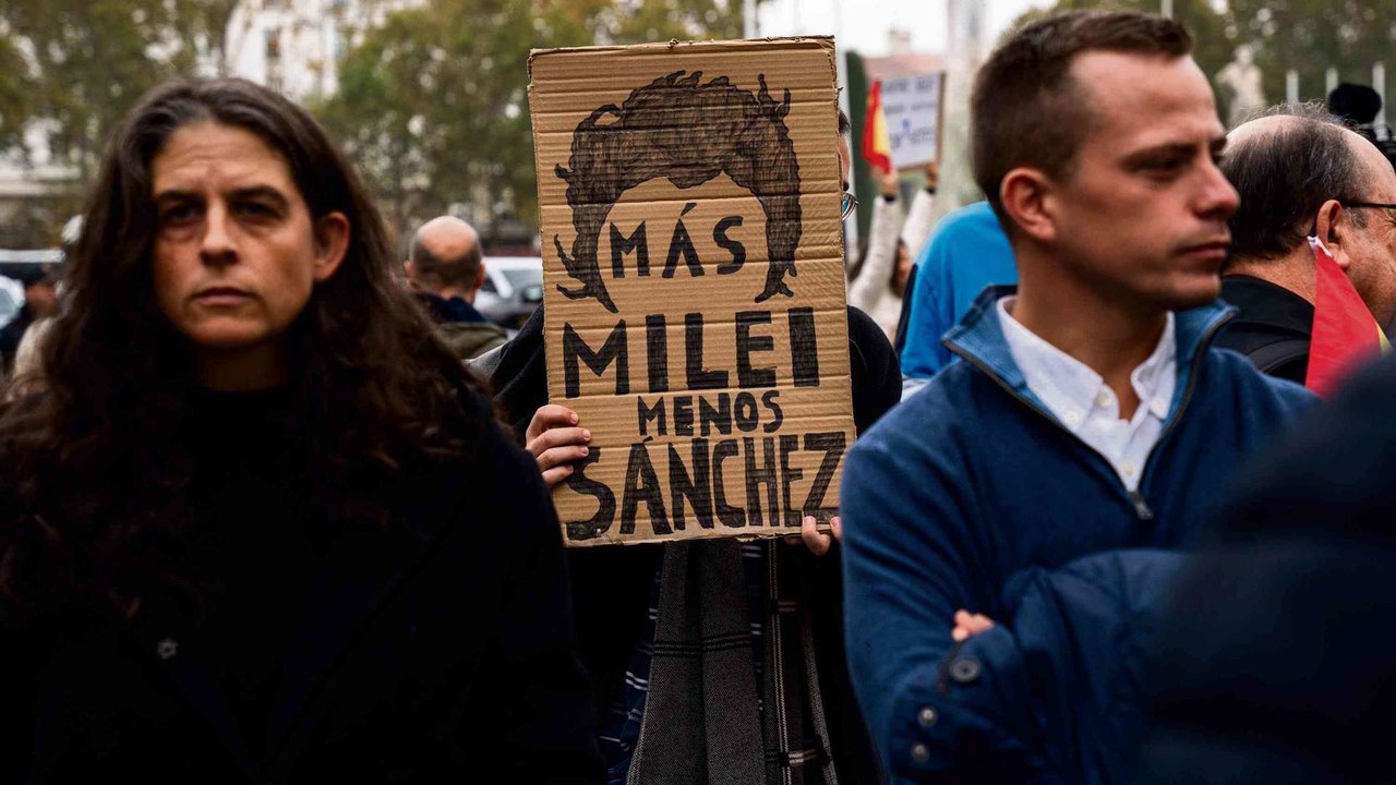 Un manifestante contra a investidura de Pedro Sánchez sostén en Madrid unha pancarta en apoio ao ultradereitista arxentino Javier Milei (Foto: Matias Chiofalo / Europa Press).