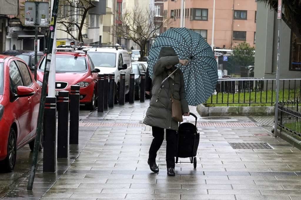 Unha muller refúxiase do vento na Coruña