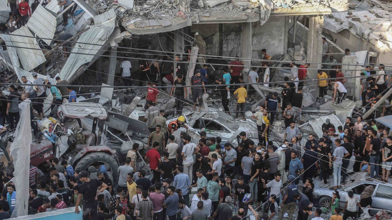 Unha multitude de persoas entre os cascallos dunha escola da ONU bombardeada por Israel este sábado (Foto: Mohammed Talatene / DPA).