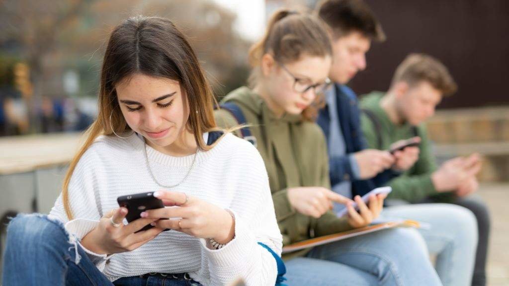 Un grupo de adolescentes pendente das pantallas dos seus móbiles. (Foto: Nós Diario).