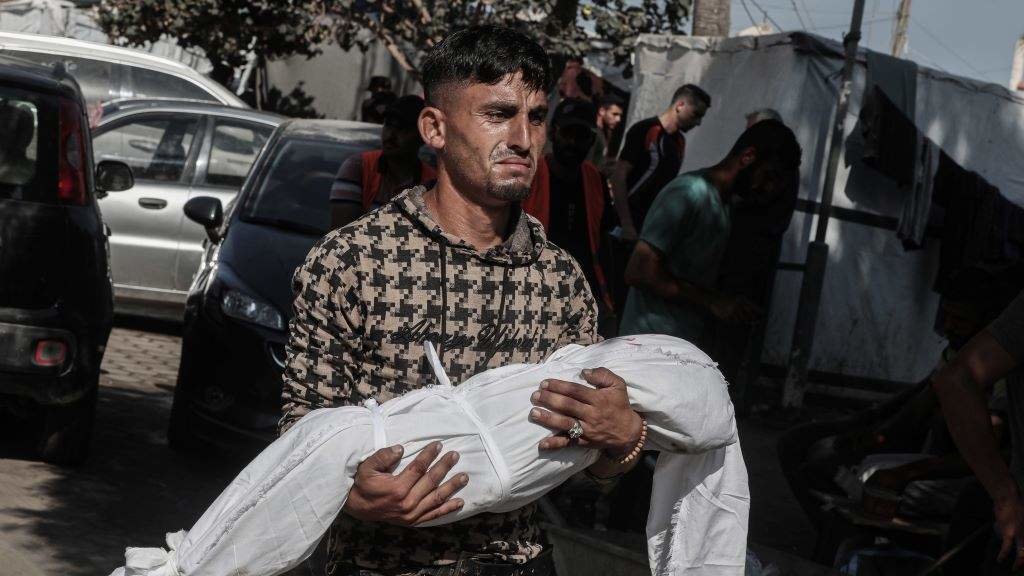 Un home sostendo o cadáver dunha crianza nos arredores do hospital de Al-Aqsa. (Foto: Omar Ashtawy / Zuma Press / ContactoPhoto vía Europa Press)