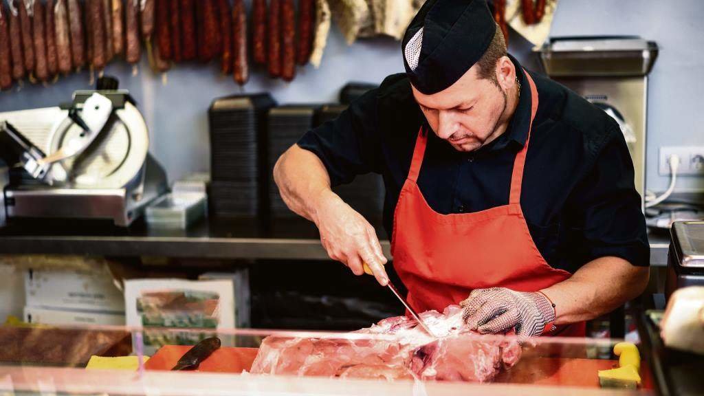 Un traballador realiza o corte dunha peza de carne nun estabelecemento comercial. (Foto: Javiindy)