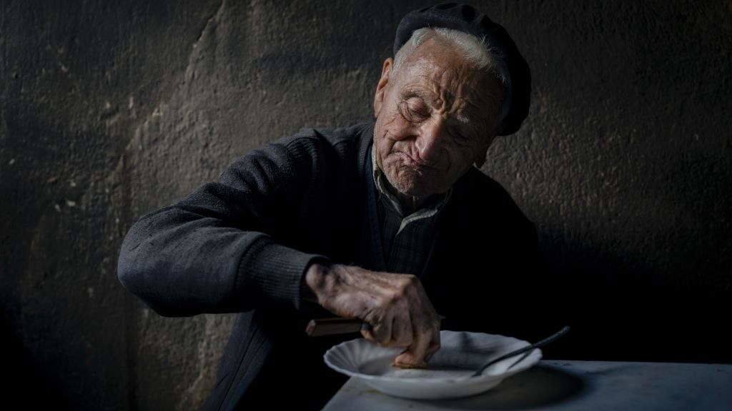 Remata o almorzo na cociña da súa casa nunha fría mañá de inverno. Ten 84 anos e vive só en Noceda, na Fonsagrada. (Foto Brais Lorenzo)