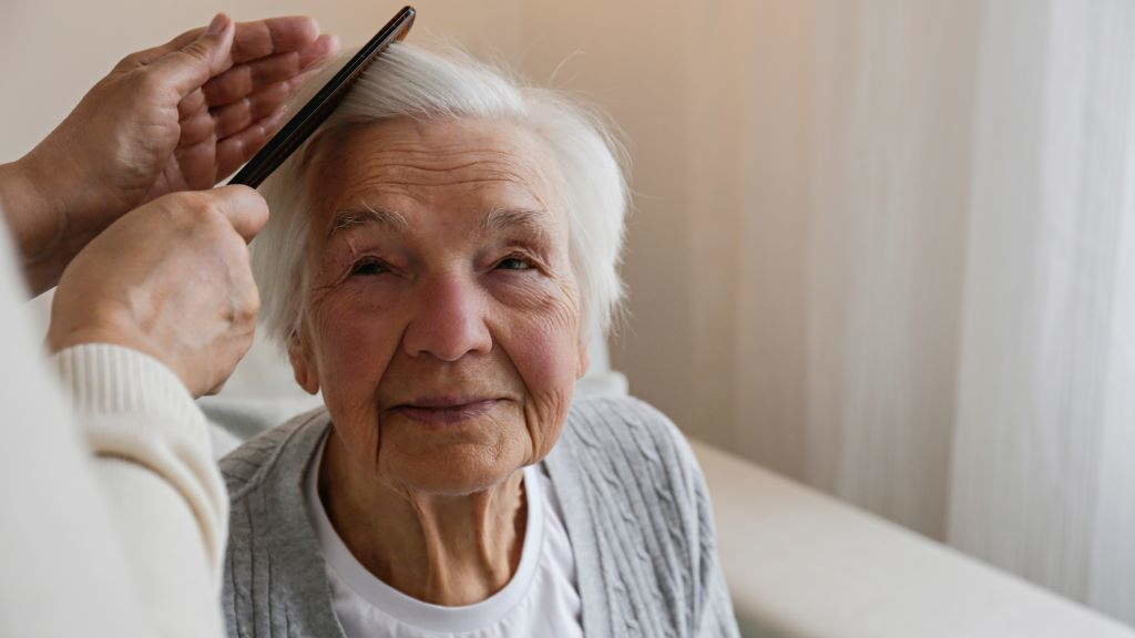 Unha muller, peiteada pola súa coidadora. (Foto: Evrymmnt)