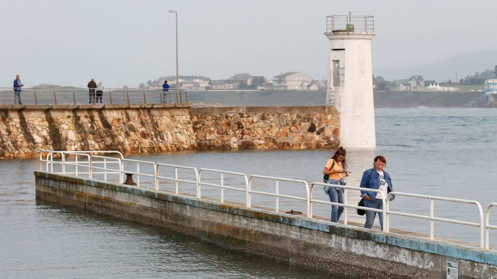 Varias persoas pasean polo espigón de Foz durante a pleamar durante o pasado 19 de setembro. (Foto: Carlos Castro / Europa Press)